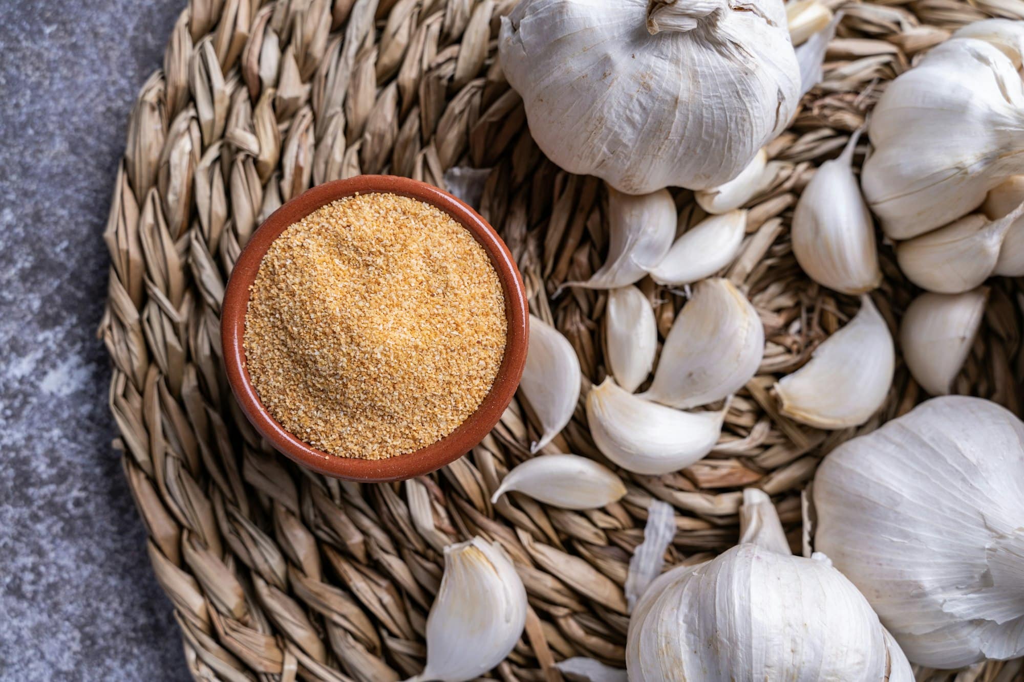 Shot of minced garlic in a bowl with white garlic on the side